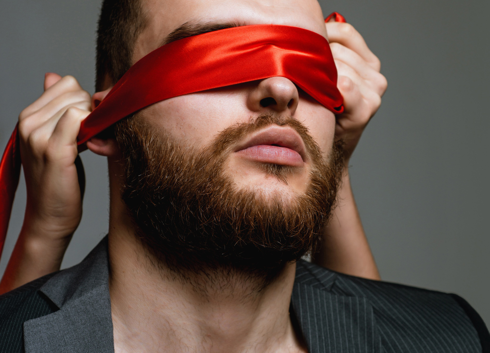 well-groomed-bearded-hipster-tied-eyes-red-ribbon.jpg